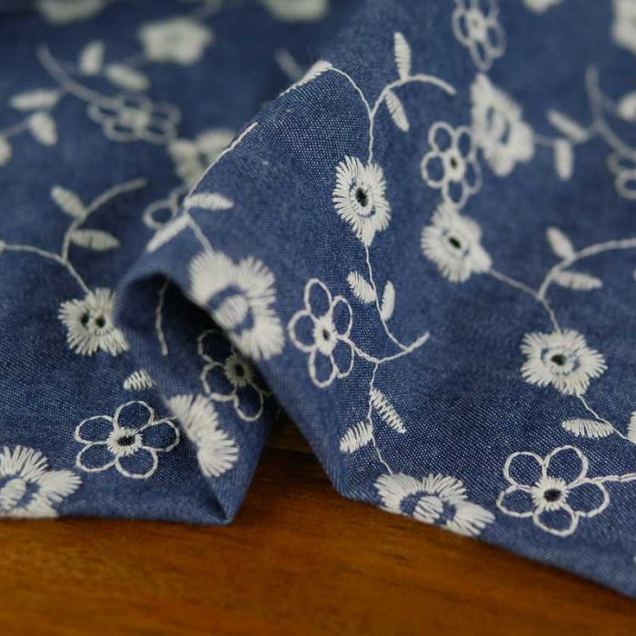 Tissu denim broderie fleurs écrues - bleu x 10 cm